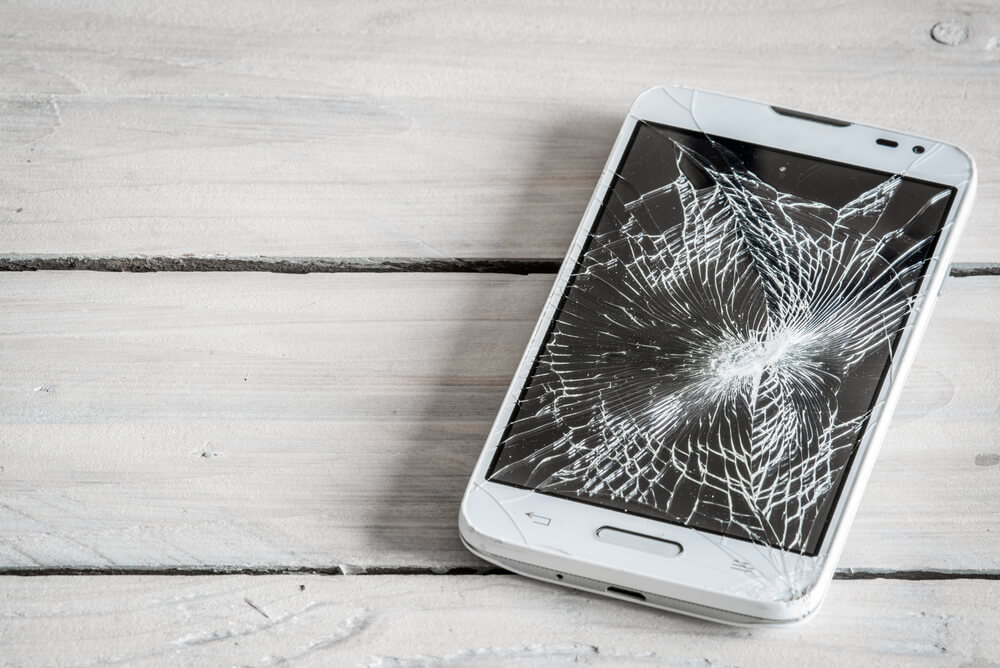 Smartphone,Display,With,Broken,Glass,On,A,Wodden,Table