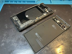 Google Pixel 7aのディスプレイを慎重に開封し、内部を分解している修理作業の風景。