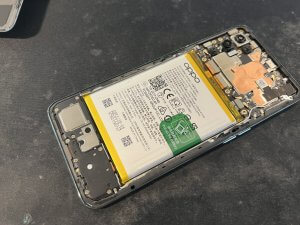 スマホスピタル横浜関内店でReno5Aの背面パネルを慎重に開封し電池交換する様子