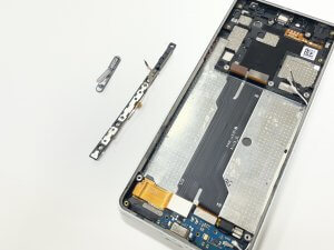 Xperia10Ⅲの背面パネルを開き、指紋認証センサー一体型の電源ボタンケーブルを慎重に交換している様子