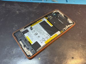 Xperia Ace IIIの電源ボタン周辺を分解して点検している様子