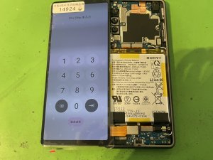 修理の途中で新しいディスプレイパネルをXperia10Ⅲに仮付けし、液晶の映りやタッチが正常かテストしている様子