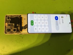 修理の途中で新しいディスプレイパネルをmotorola edge 50に仮付けし、画面の表示やインカメラの映りに問題がないかテストしている様子