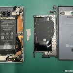 背面から分解し被膜が破れた危険な膨張バッテリーを慎重に取り外しているPixel7a
