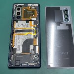 内部の複雑なケーブルに注意しながら背面からバッテリーを取り外しているXperia5