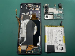 基板とバッテリーを取り外してフレーム奥のスリープボタンケーブルを交換しているXperia1 IV