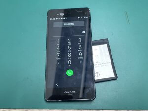 背面から分解し新しいバッテリーを仮付けして起動テストを行っているarrowsNX