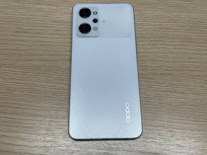 背面パネルを温めながら丁寧に開口作業を進めているOPPO Reno9 A